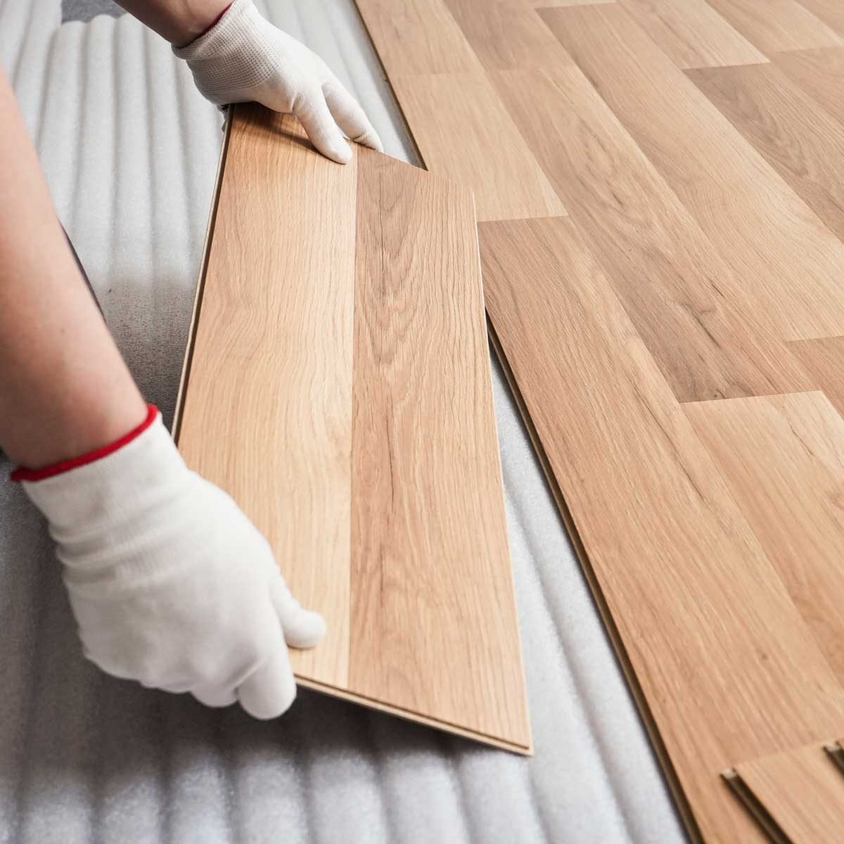 Flooring installer placing luxury vinyl plank flooring
